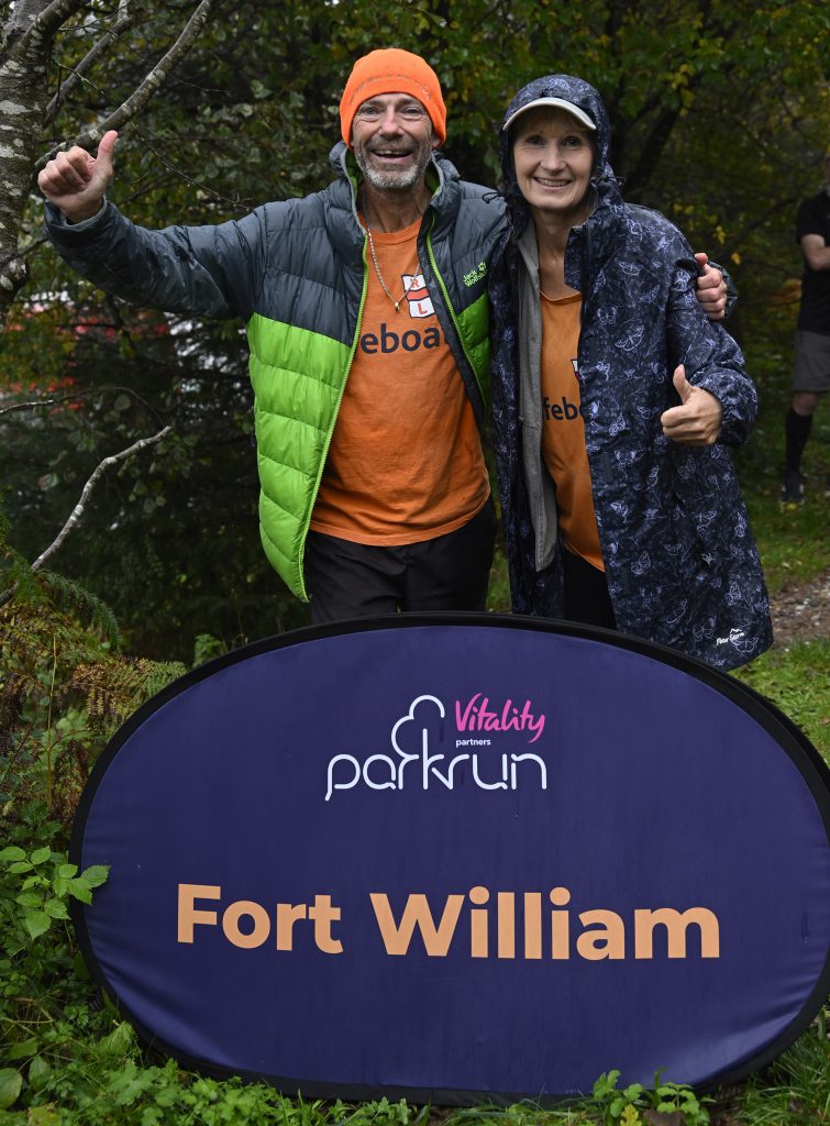 Couple walking UK coast pause for Fort William parkrun